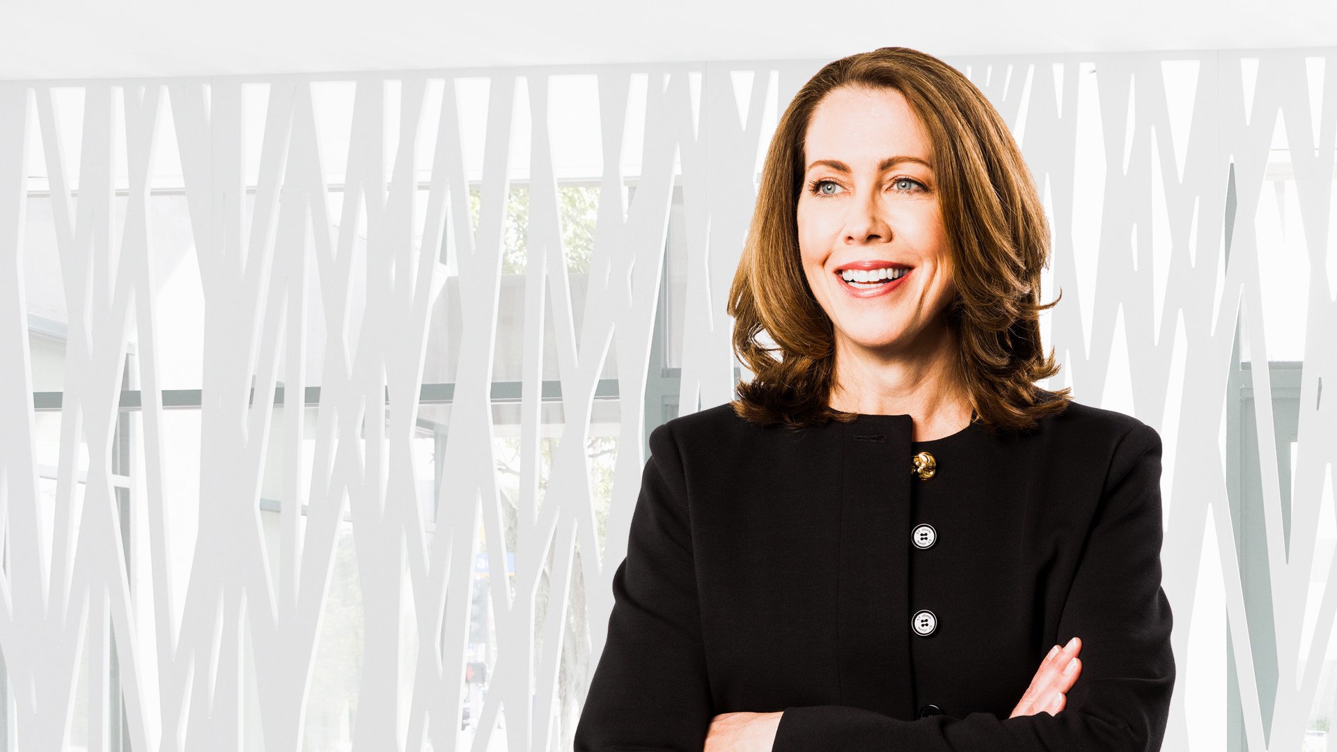A woman with shoulder-length brown hair wearing a black blazer
