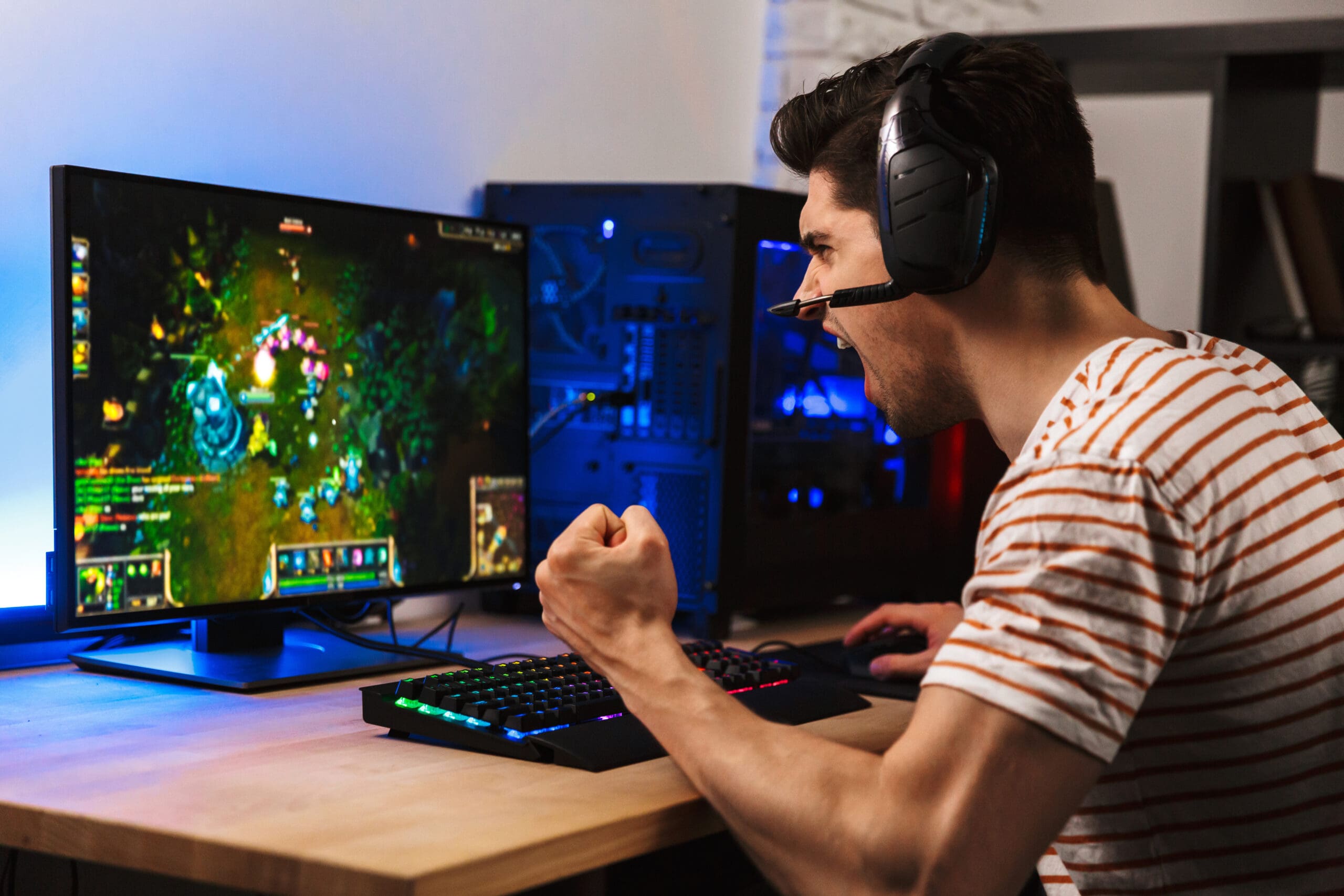 A man enthusiastically playing a video game on his computer
