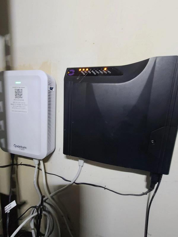 Two network devices mounted on a beige wall