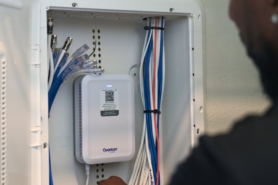 A close-up view of a person working inside an open network box